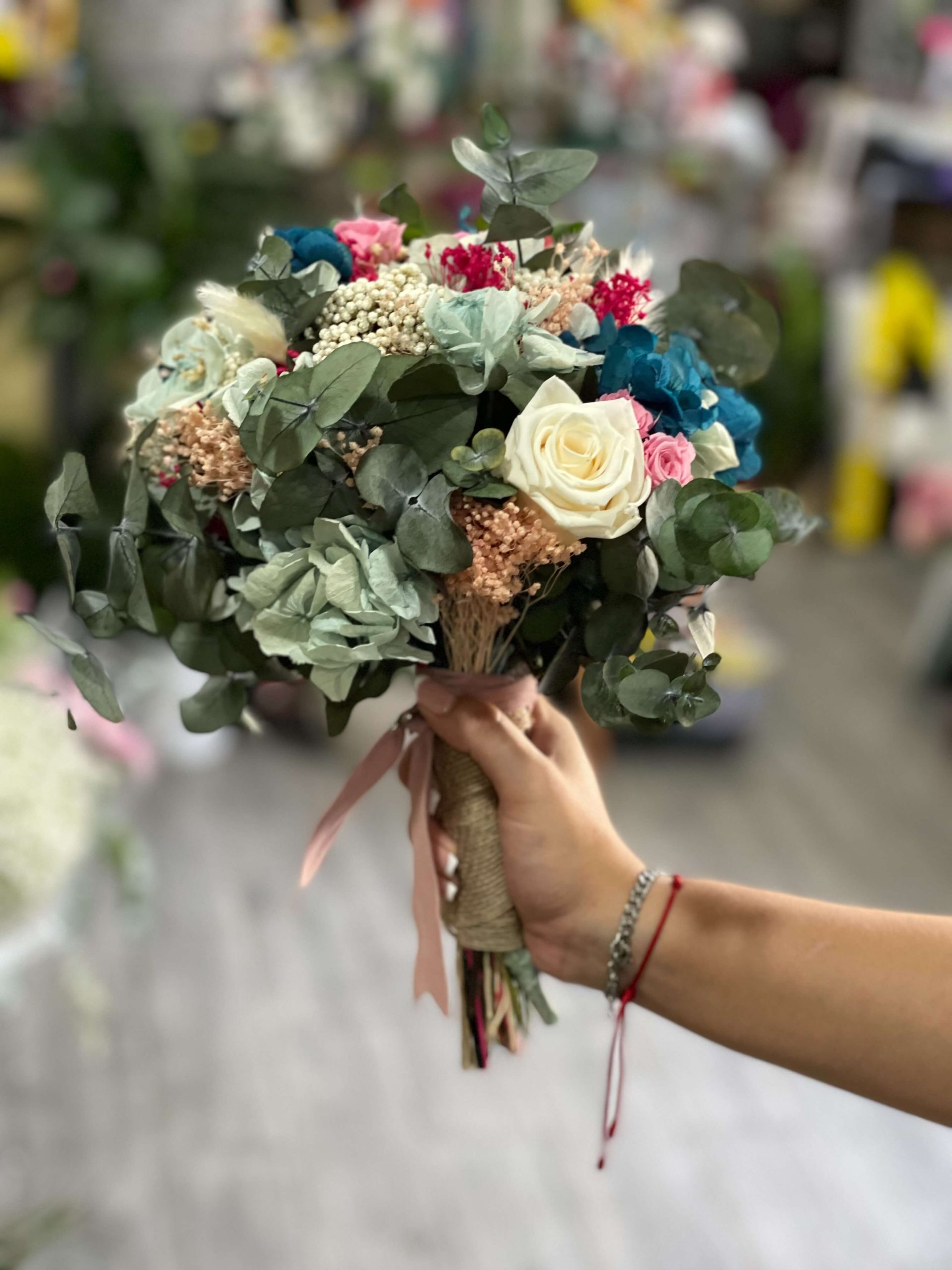 ramo de flores variadas de color blanco y rosa con diferentes toques de verde